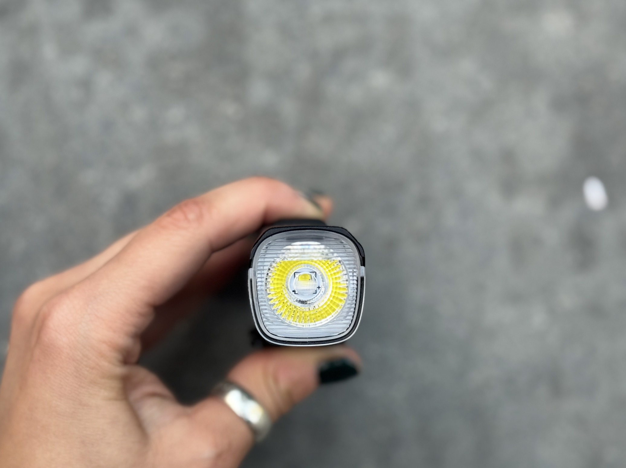 A small tube with anti glare yellow ring held in a hand.