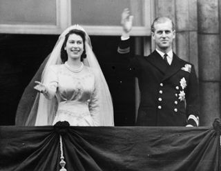 Queen Elizabeth and The Prince Philip, Duke of Edinburgh waving to a crowd from the balcony of Buckingham Palace