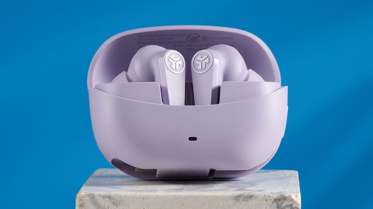 the jlab go pods anc earbuds in lilac with a lilac charging case and built in usb-c cable against a blue background on a marble stand