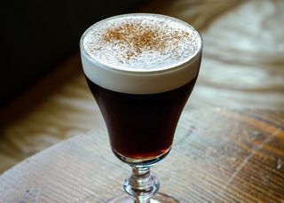 a coffee cocktail in an Irish coffee glass with a think foam topping