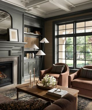 dark blue moody living room with blush velvet armchairs and large windows