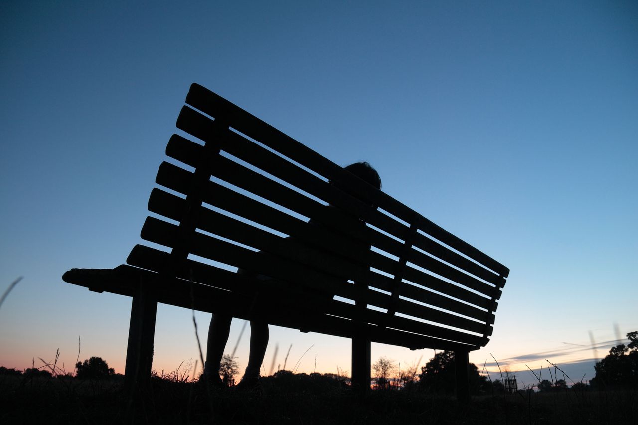 A child alone on a bench. 