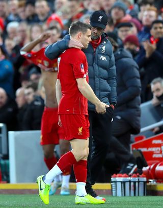 Klopp, right, consoles the injured James Milner in the FA Cup tie with Everton