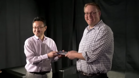 Two men holding a game in their hands