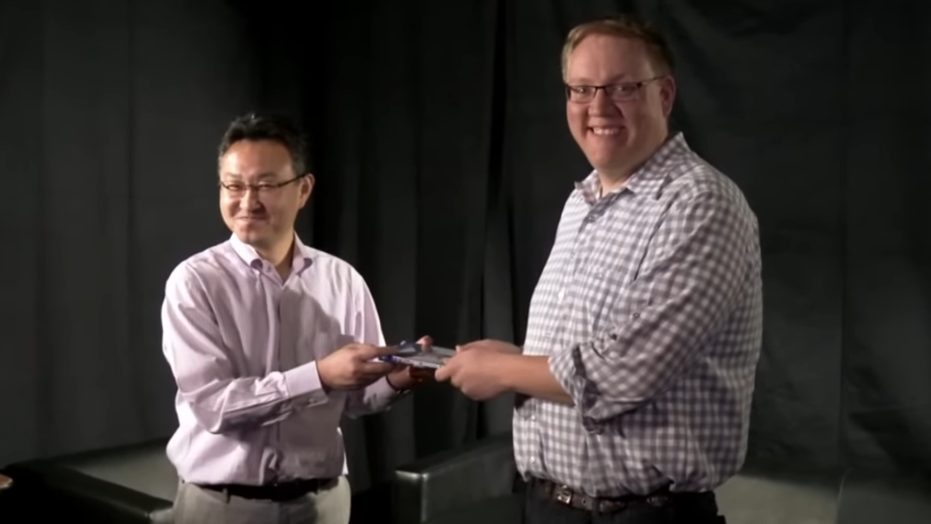 Two men holding a game in their hands