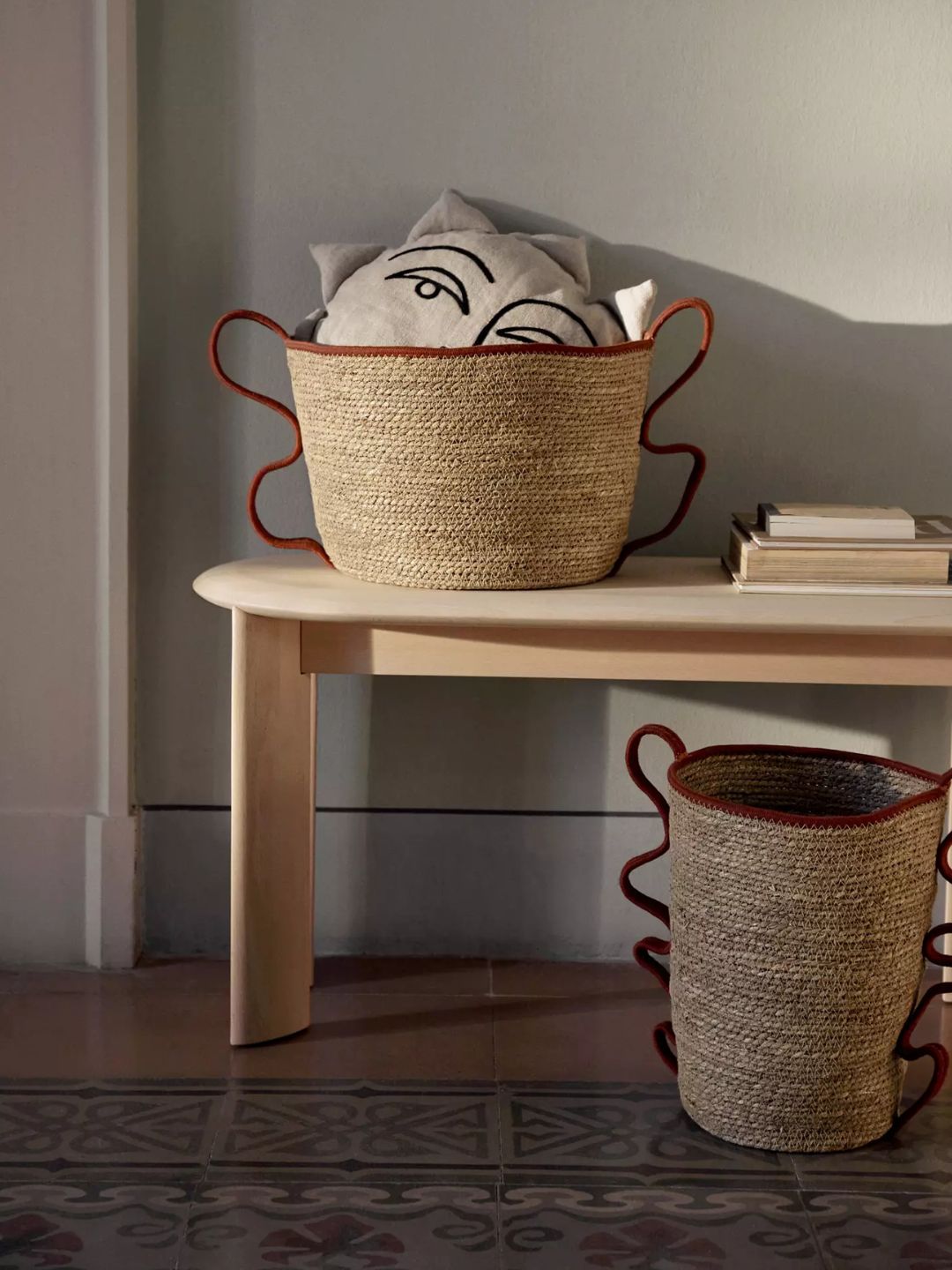 A woven basket with red handles from Ferm Living