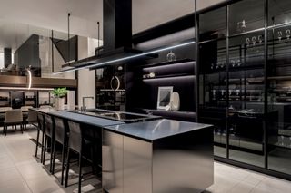 a black and stainless steel modern kitchen in a showroom