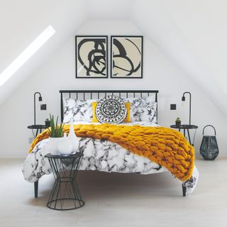 Neutral bedroom with soft grey carpet, white walls and grey and white bed with chunky mustard throw