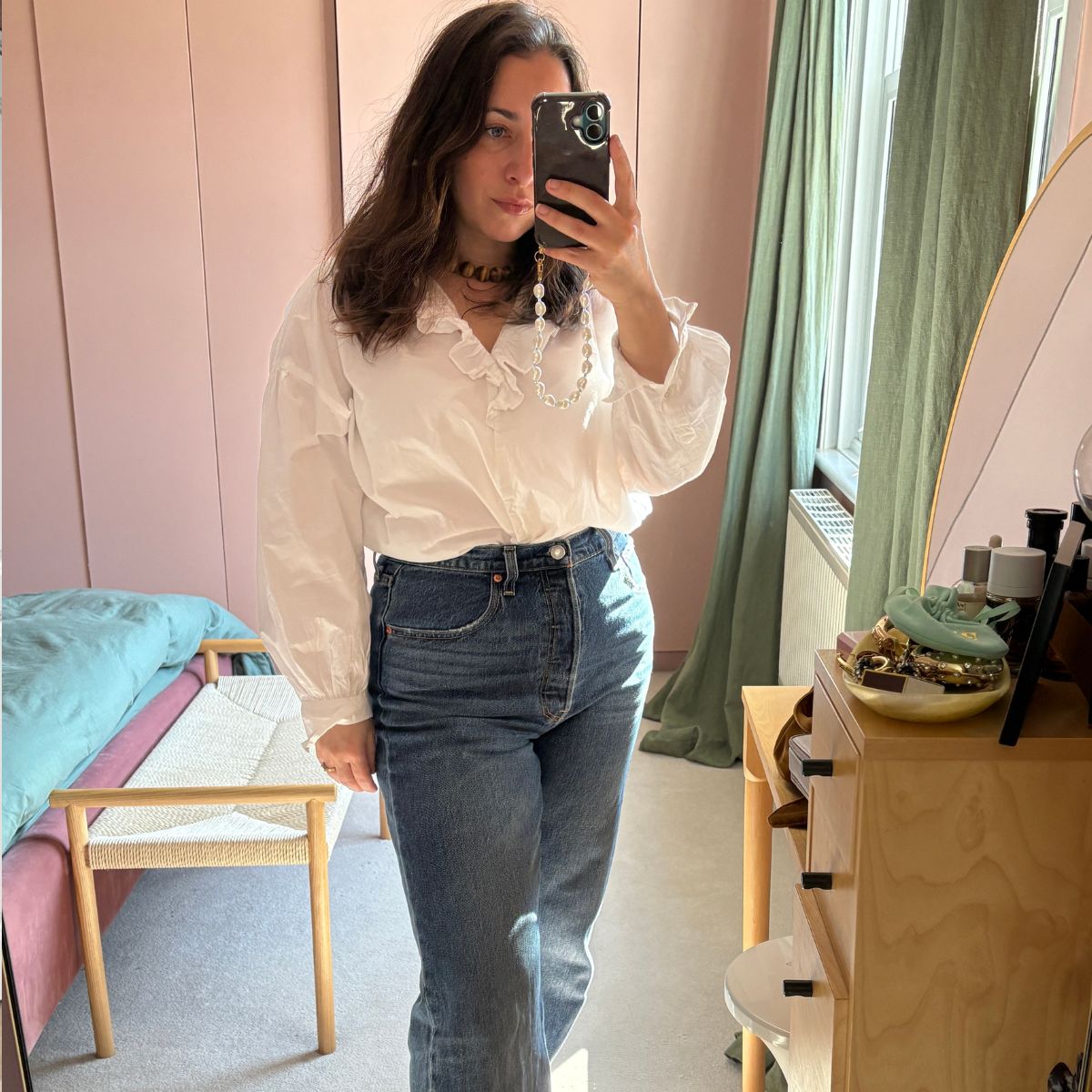 An image of Who What Wear editor-in-chief Hannah Almassi trying on and reviewing the best Levi's jeans.