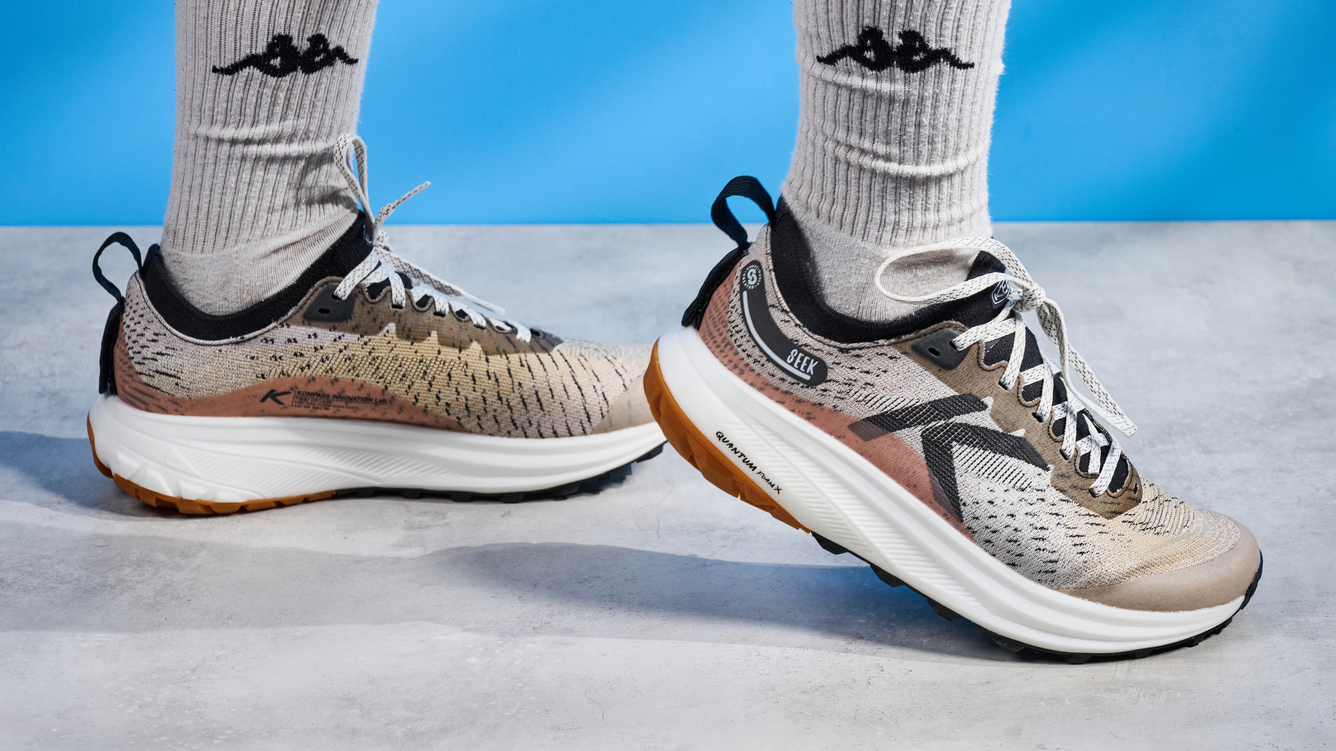 the keen seek trail shoes in brown, black, and beige photographed against the blue tom's guide background