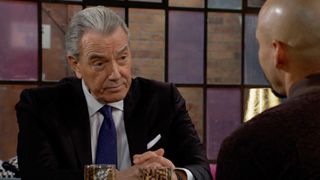 Eric Braeden as Victor Newman sitting at a lunch table in The Young & The Restless