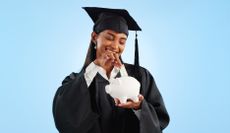College graduates puts money into a piggy bank.