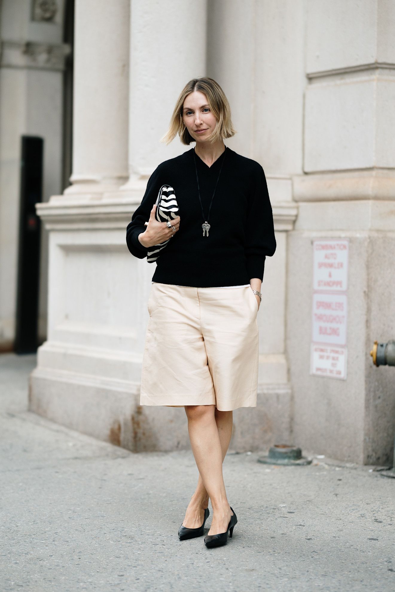 woman wearing sweater, jorts, and kitten heels
