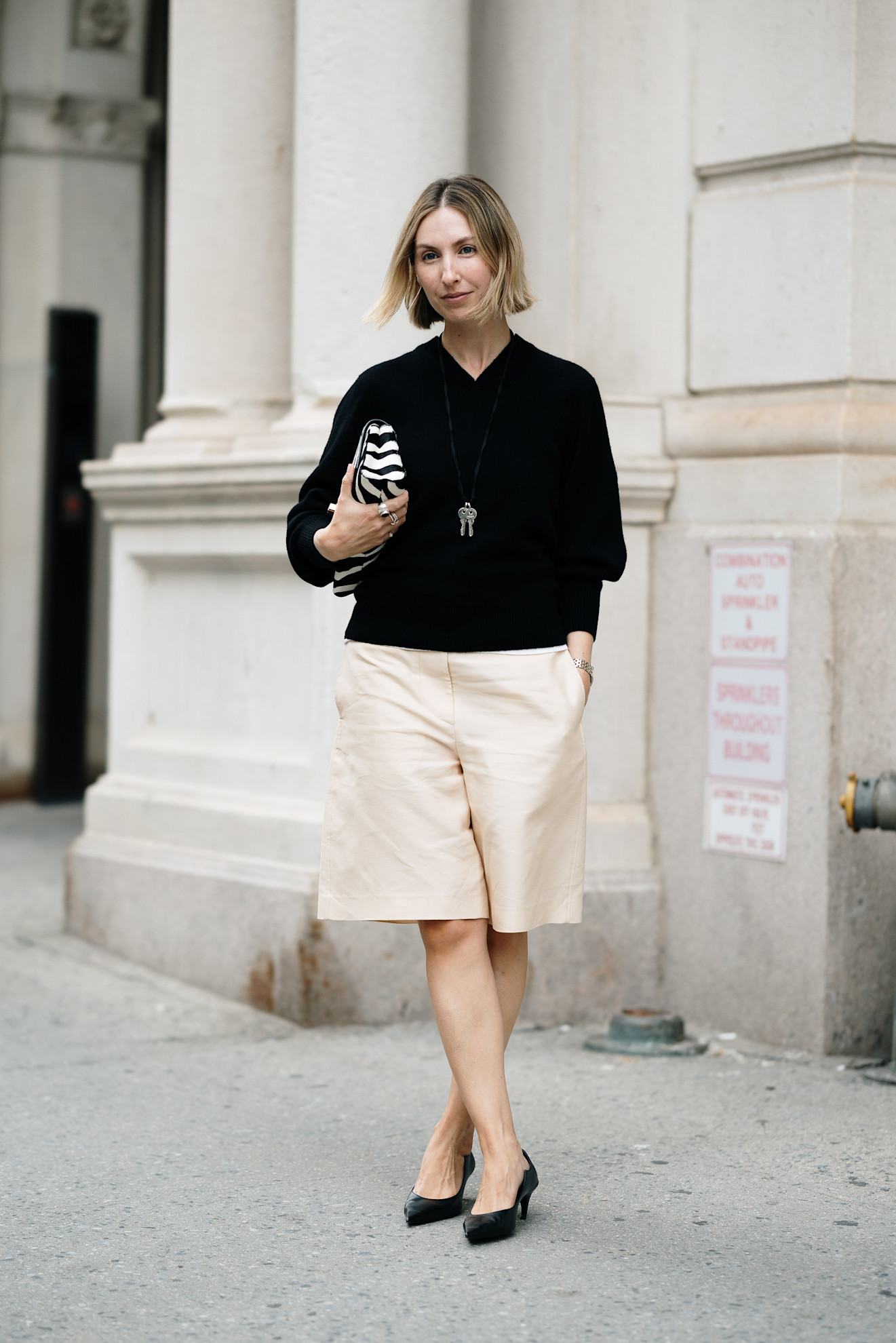 woman wearing sweater, jorts, and kitten heels
