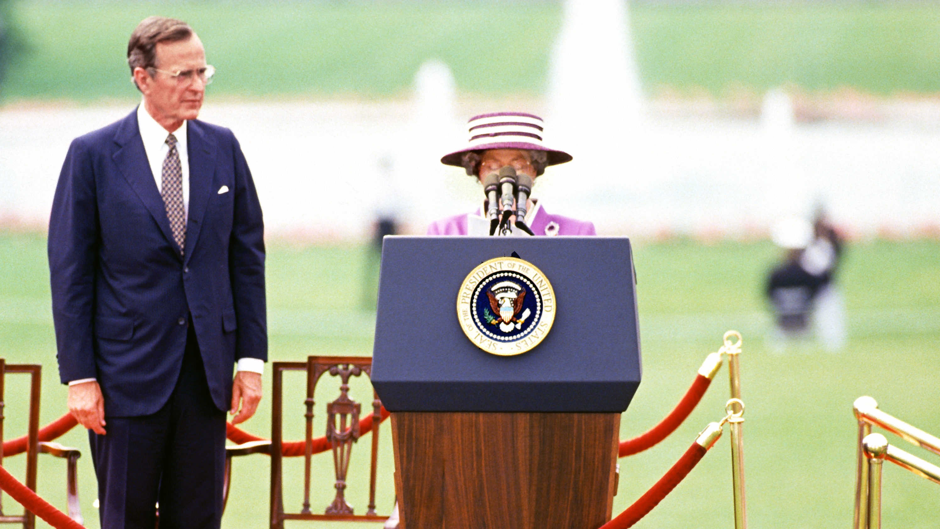 US President George HW Bush (left) listens as Queen Elizabeth II delivers remarks during a State Visit, Washington DC, May 14, 1991