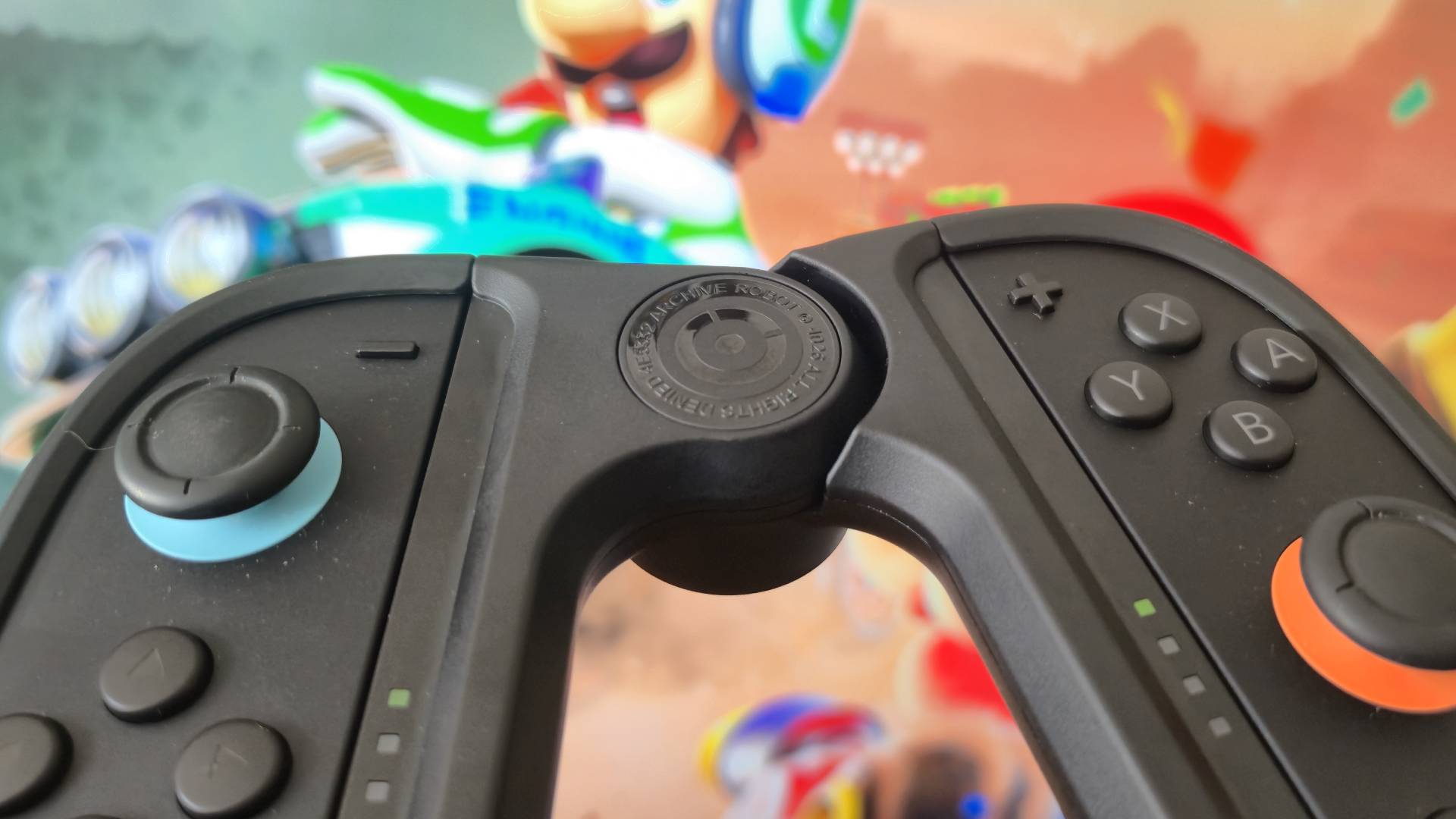 Close up of the Joy-Lock controller holder with Mario Kart World running behind it.