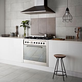 kitchen room with white tiled flooring and tiled walls