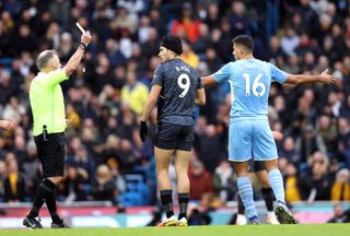 Referee Jon Moss shows a first yellow card to Wolves’ Raul Jimenez