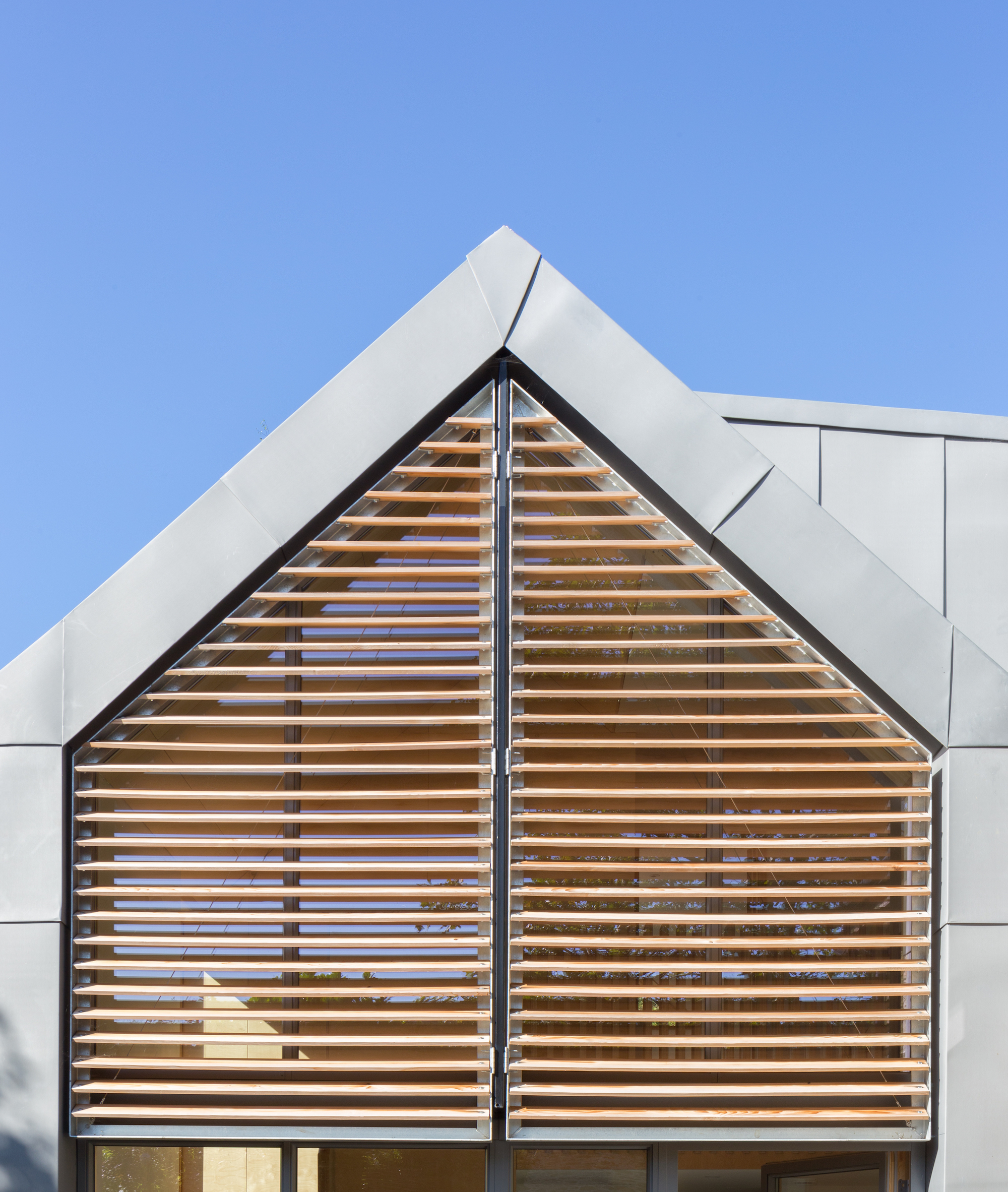 pitched roof extension with zinc roof and timber louvres