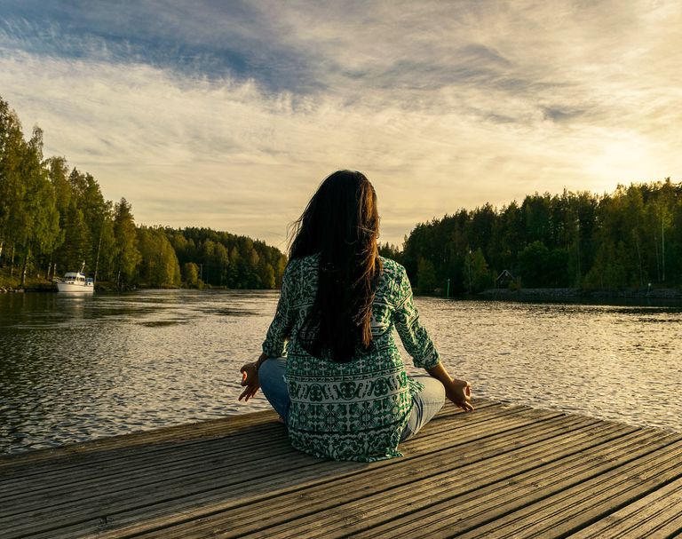 Woman meditating by lake