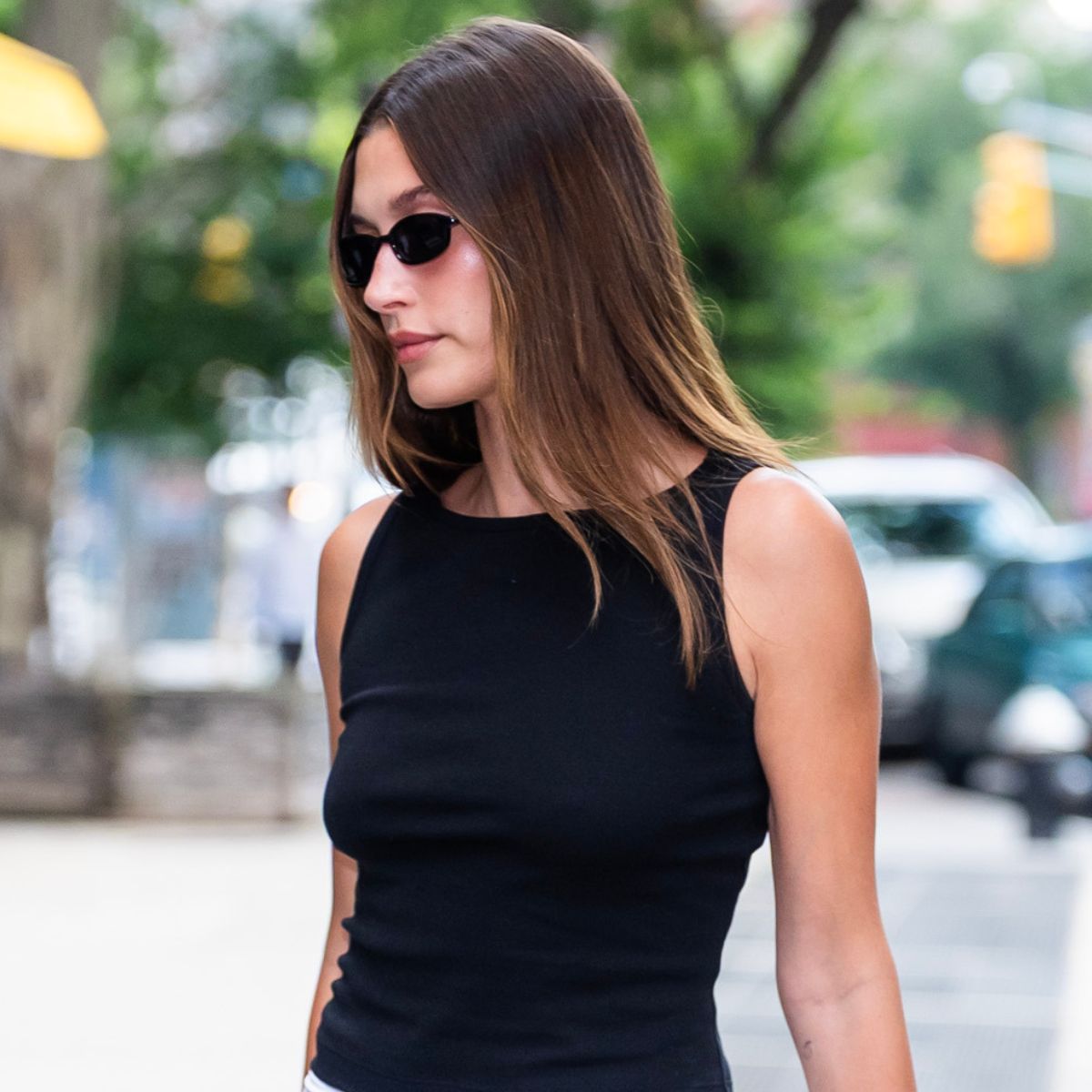 hailey bieber wearing black sunglasses and black vest
