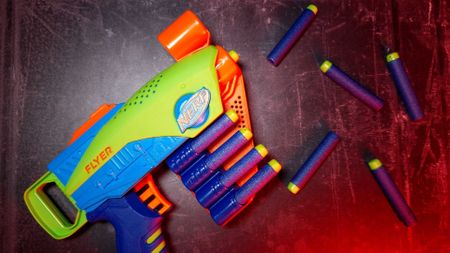 A Nerf Elite Jr. Flyer sitting beside Nerf Elite darts