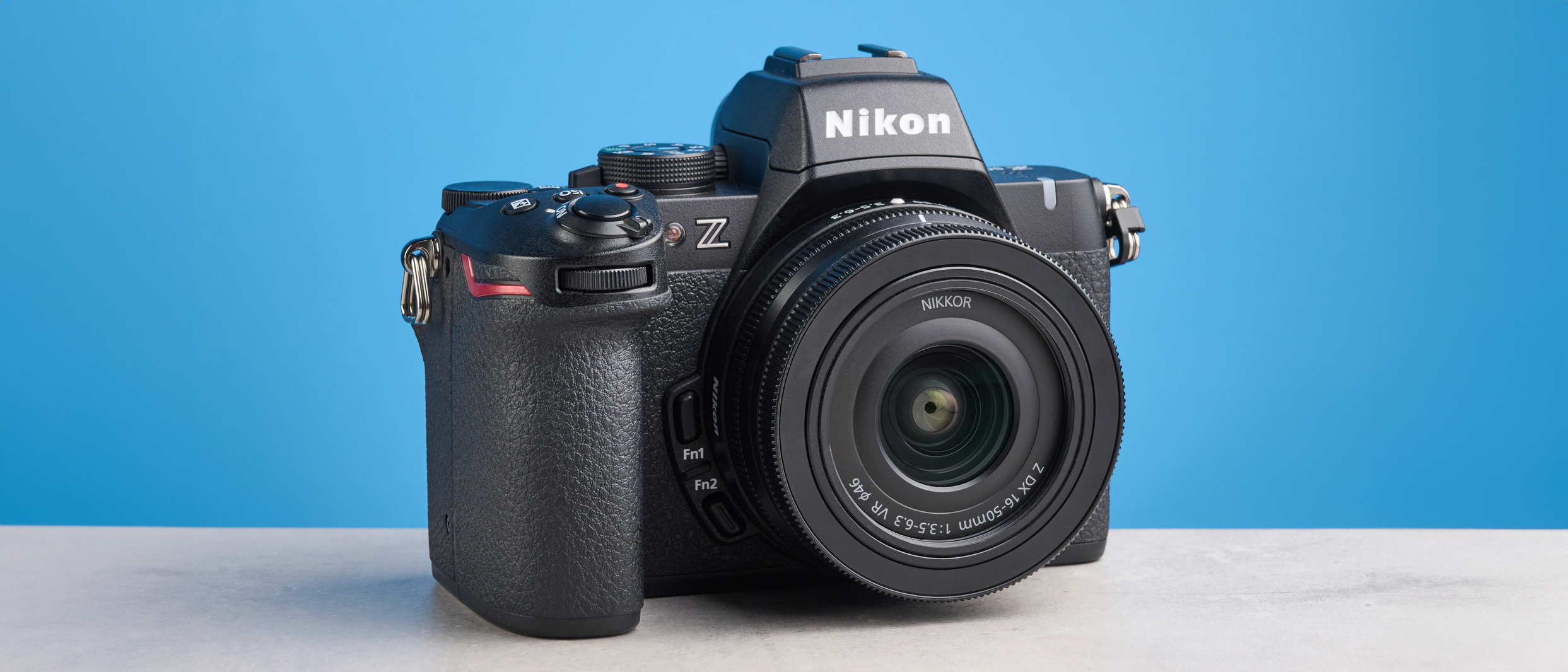 The Nikon Z50II on a stone surface with a blue background