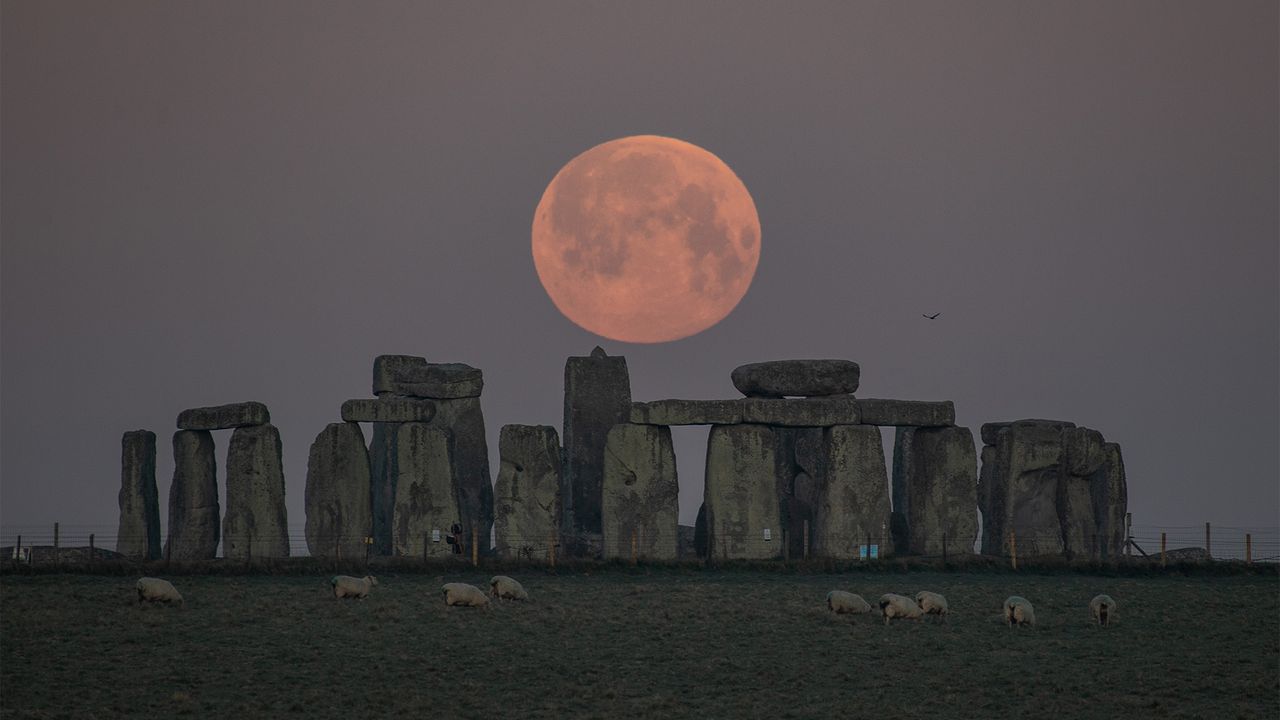 The Super Pink Moon is seen over Stonehenge in Amesbury, England, during the early morning of April 27, 2021.
