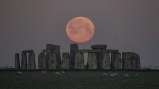 The Super Pink Moon is seen over Stonehenge in Amesbury, England, during the early morning of April 27, 2021.