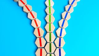 Three lines of wooden hexagonal blocks that diverge into three discrete lines, on a bright blue background