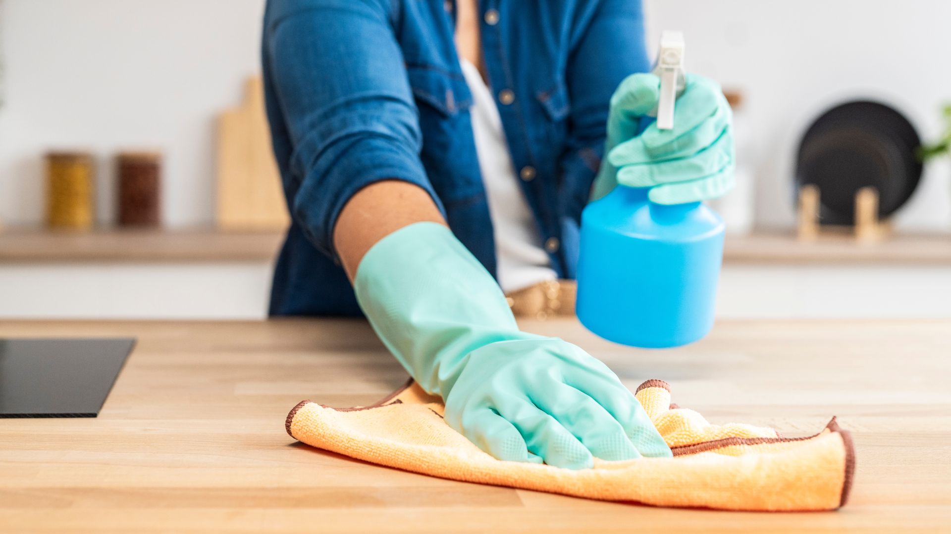 picture of woman wiping counter tops with wipe and spray