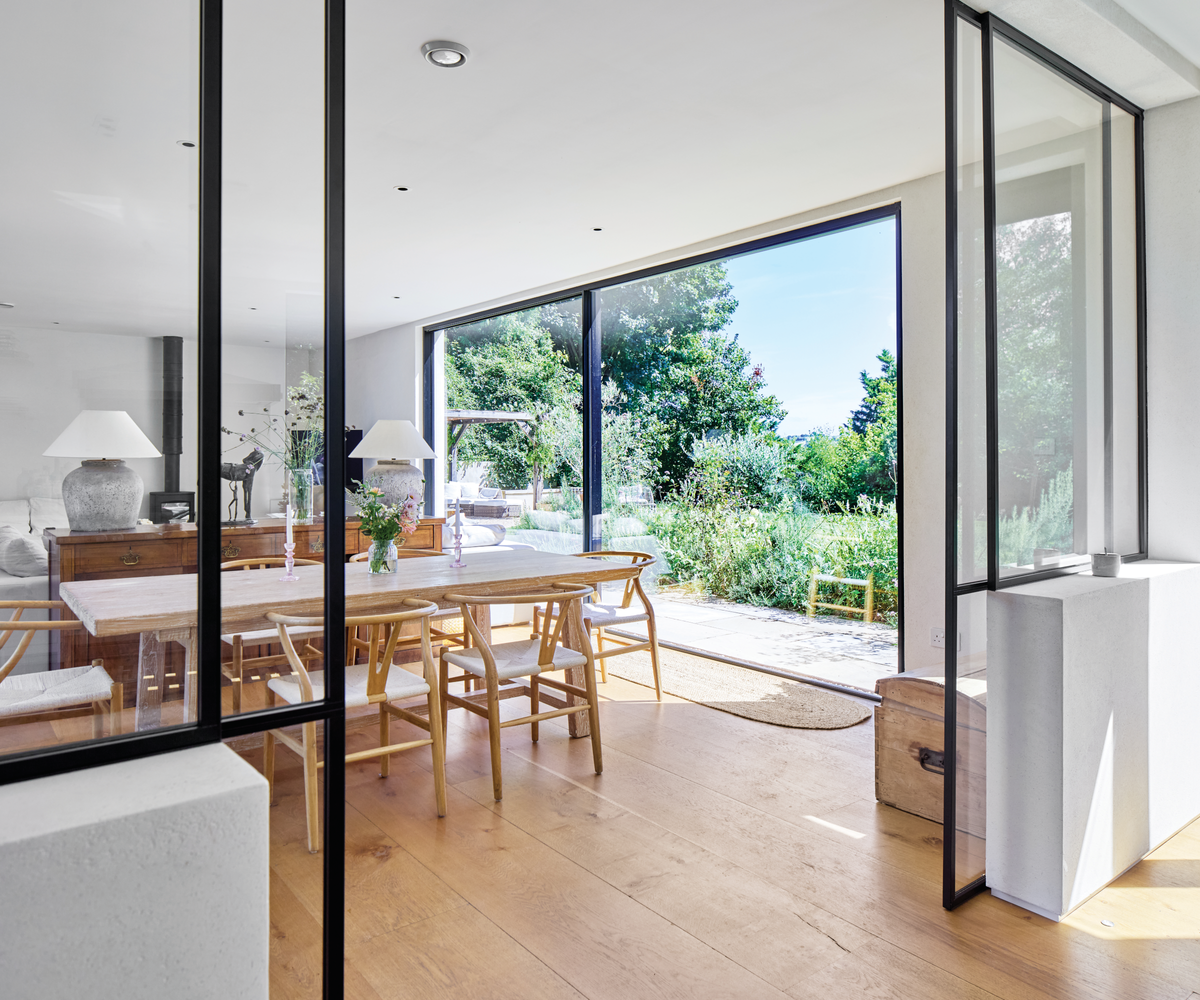 Dining room with sliding doors opening up onto garden with black trim