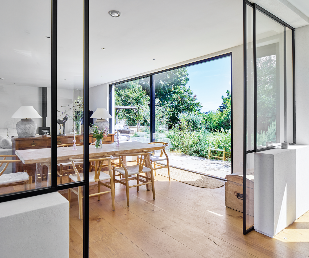 Dining room with sliding doors opening up onto garden with black trim