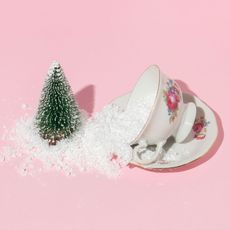 cup of sugar near miniature Christmas tree