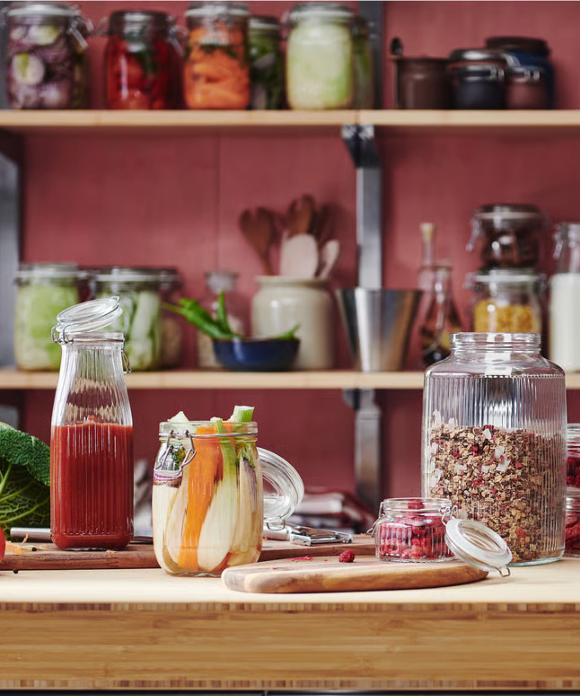 Cherry red kitchen with wooden sideboard showcasing fluted glass food storage jars