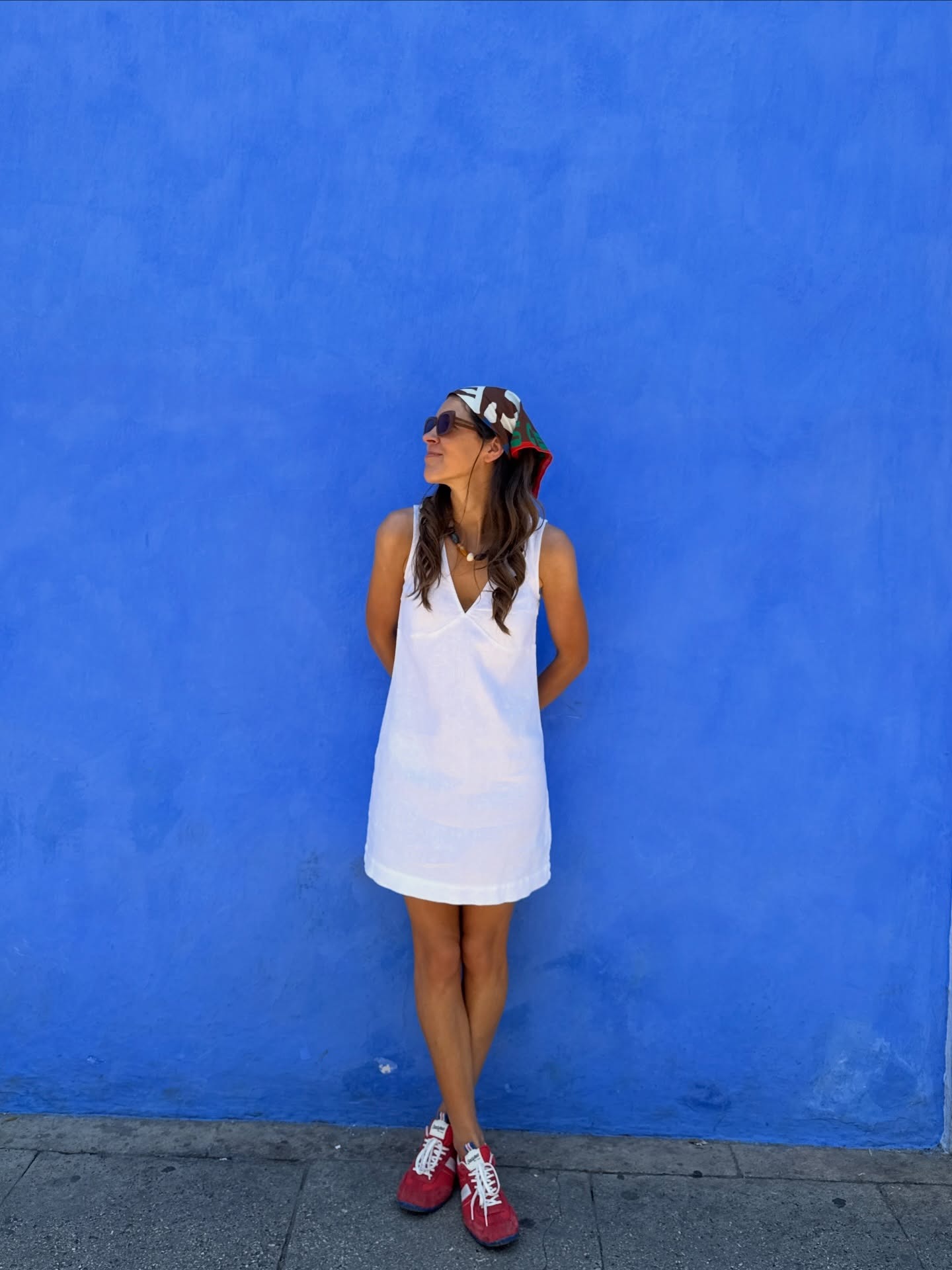Woman in a white linen dress and sneakers