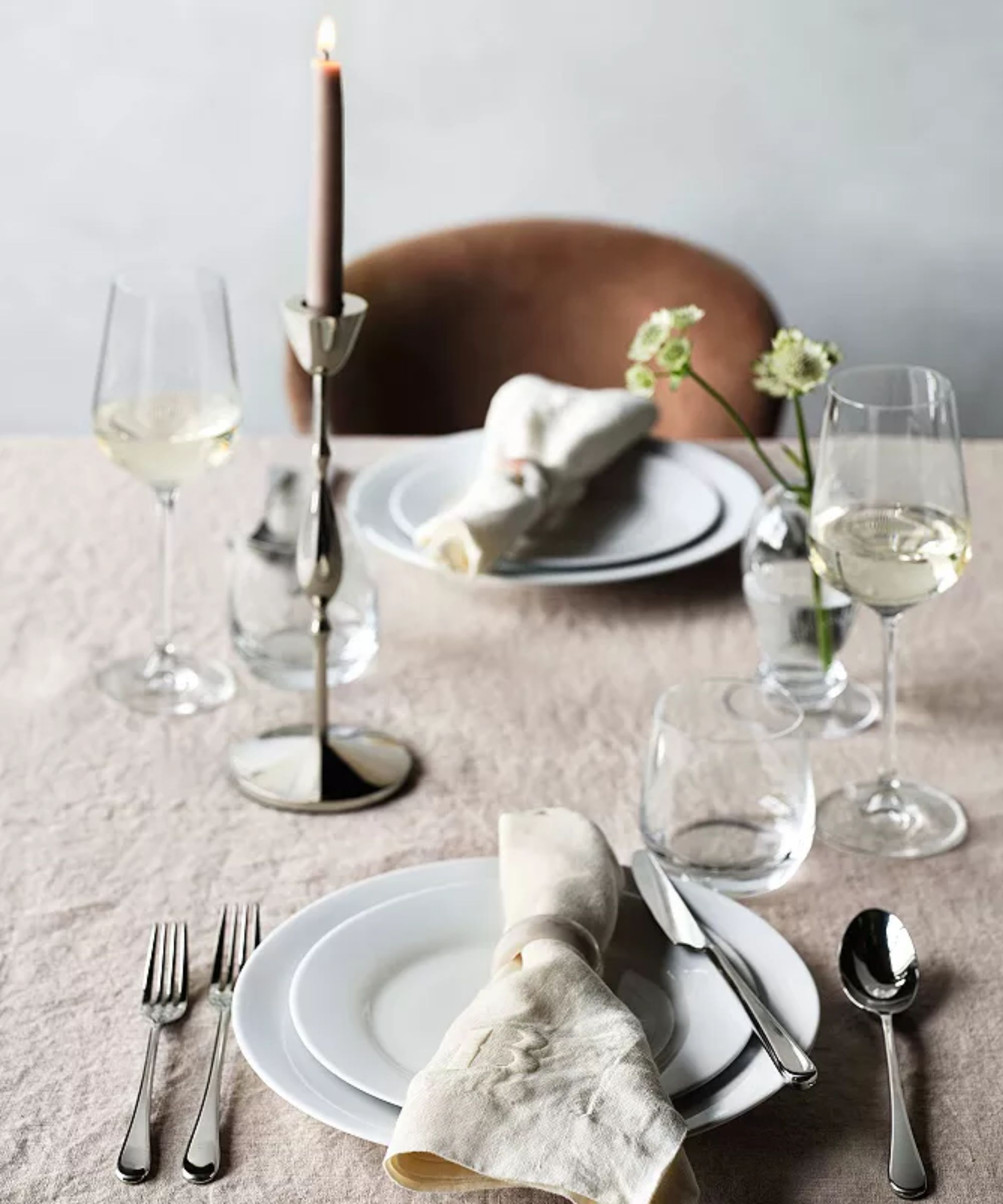 Natural linen tablecloth with matching napkins, white plates, silver flatware and silver taper candlesticks