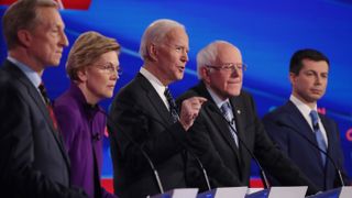 Tom Steyer (L), Sen. Elizabeth Warren (D-MA), Sen. Bernie Sanders (I-VT) and former South Bend, Indiana Mayor Pete Buttigieg (R) listen as former Vice President Joe Biden (C) speaks during the Democratic presidential primary debate at Drake University on Jan. 14, 2020 in Des Moines, Iowa.