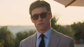 Eddie Redmayne looking into the distance with sunglasses on in The Day of the Jackal.