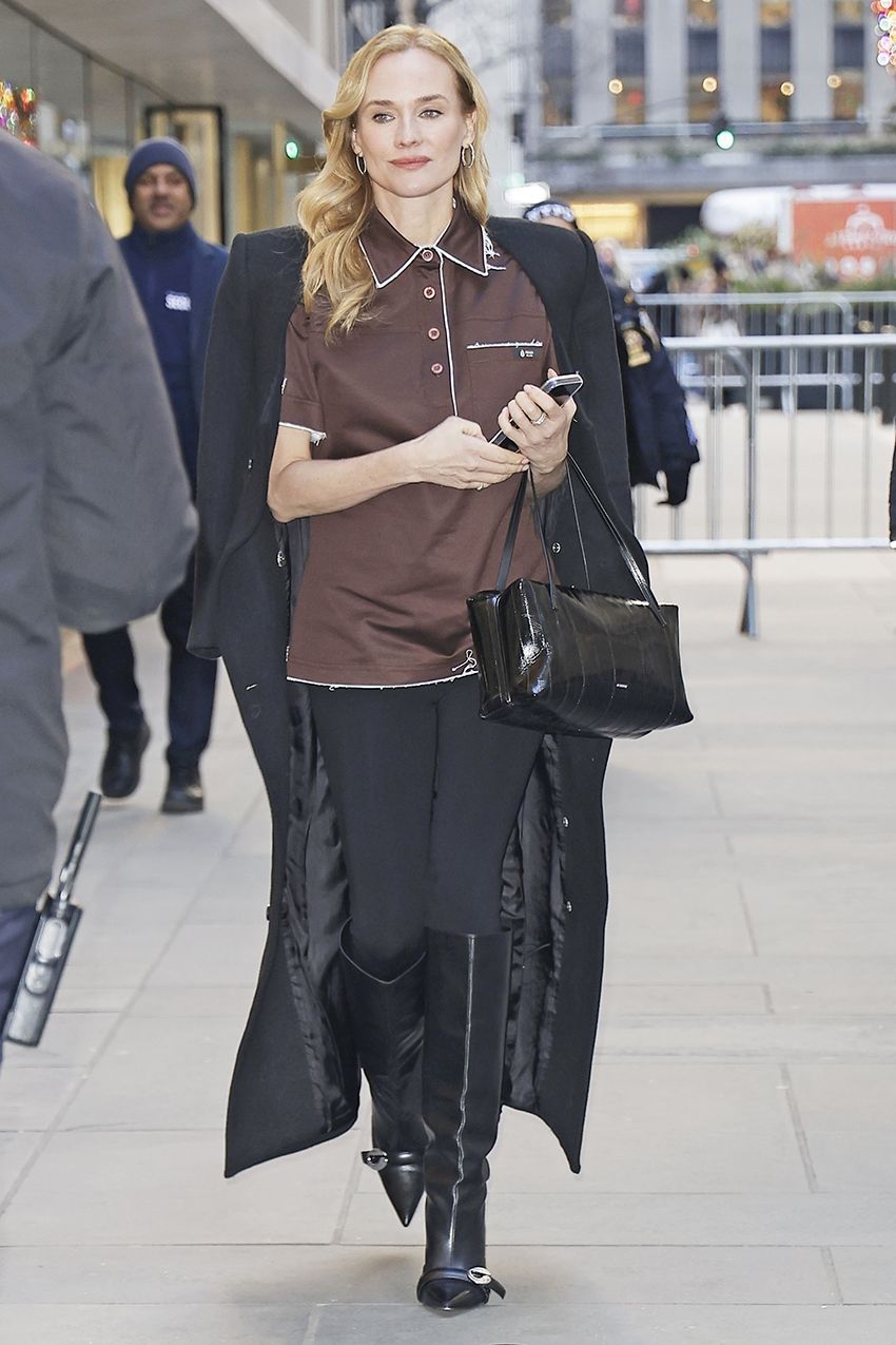 Diane Kruger wearing a brown Prada polo shirt, black coat, black leggings, and black leather knee boots in NYC