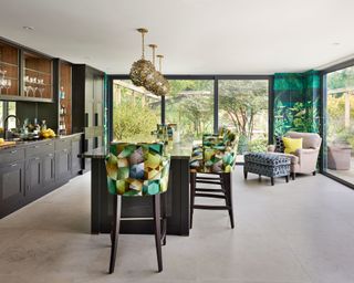 Pool house ideas inside, featuring a kitchen and geometric stools and curtains.