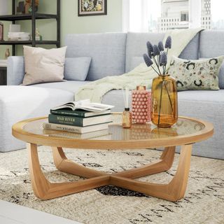 A wooden and glass circular coffee table