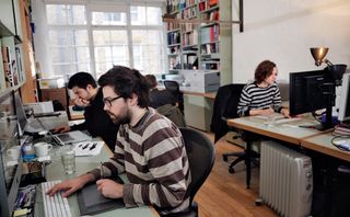 Daniel Streat (foreground, stripes) designs alongside Barnbrook, and recently created graphics for some of his work with John Foxx. Tzortzis Rallis (background) freelances in the studio.