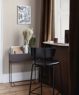 A grey planter box with black chair and marble window ledge