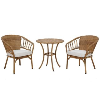 A wicker bistro set in natural wood with white cushions