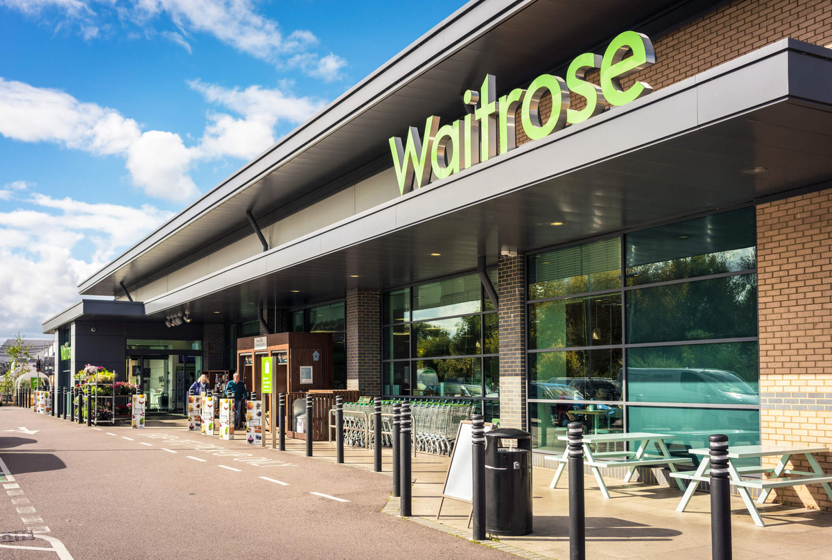 Front of Waitrose store with people leaving pushing trolleys