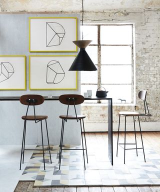 Kitchen pictures showing a large, light kitchen with abstract art and pendant lighting over the table.