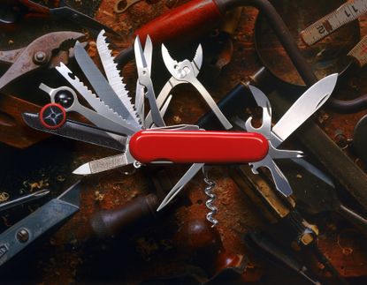 A red "Swiss Army" style of knife, with multiple tools opened.