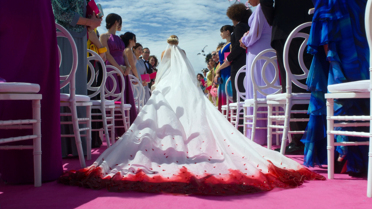 The train of Blake Lively's wedding dress shown against a pink carpet in Another Simple Favor.