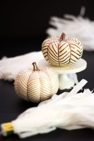 White pumpkins with gold line detail on cake stands for display
